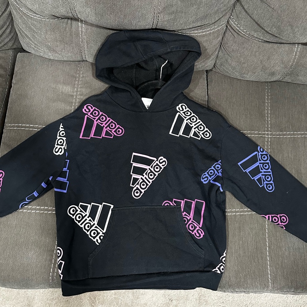 Black hoodie with Adidas branded on the sweatshirt in purple and white letters
